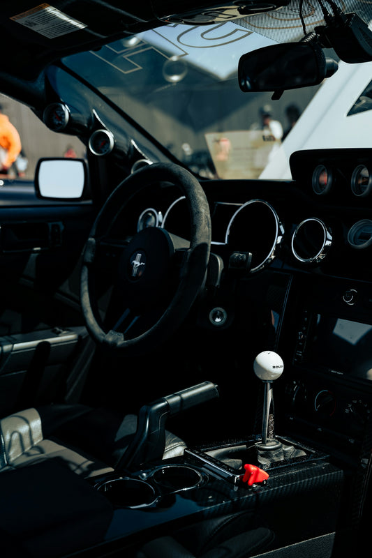The interior of a car with a steering wheel and dashboard