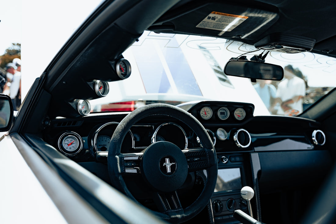 A close up of a steering wheel and dashboard of a car
