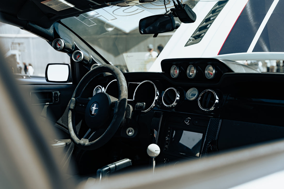 The interior of a car with a steering wheel and dashboard